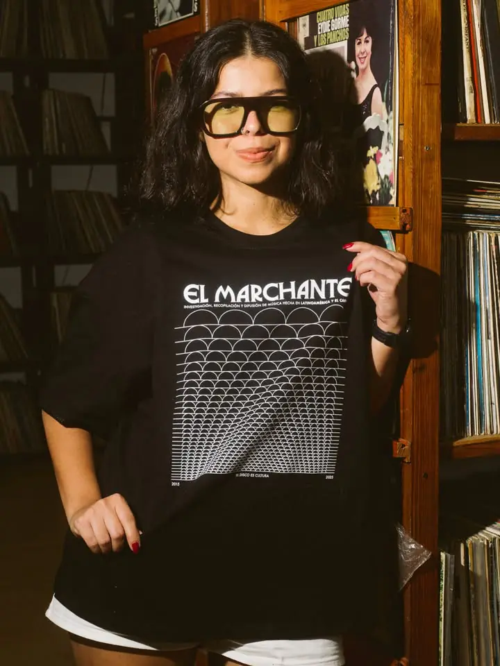 El Marchante T-Shirt by CRINI, worn among record shelves