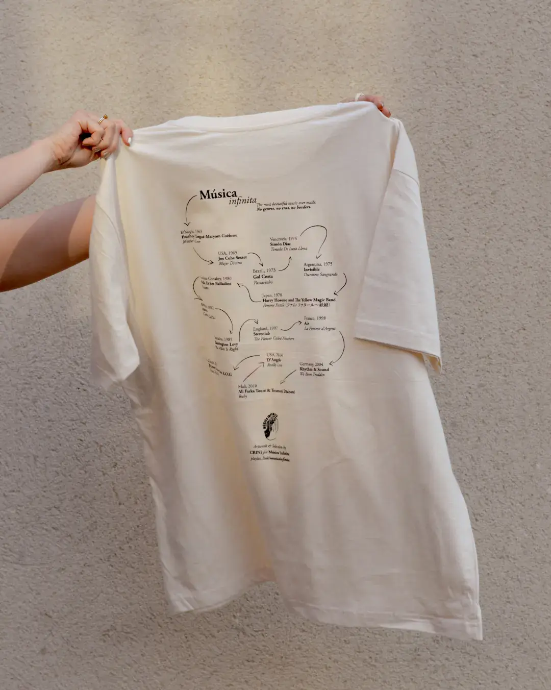Música Infinita T-Shirt by CRINI, line-drawn back print held up to the light