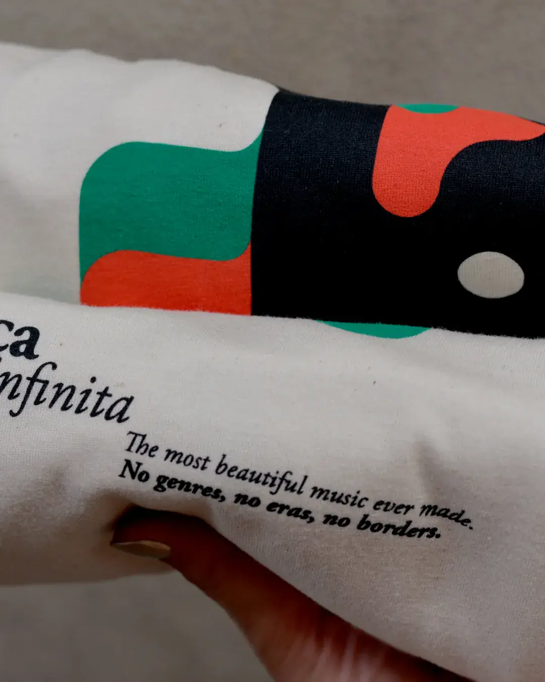 Música Infinita T-Shirt by CRINI, sleeve detail with the printed motto